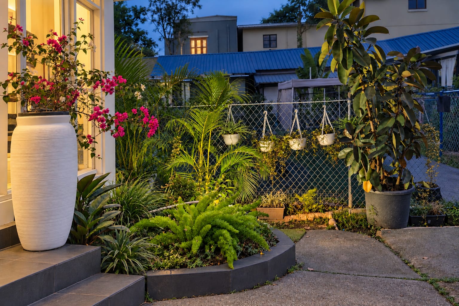 A white urn of pink bougainvillea and potted palms along the garden path in the evening